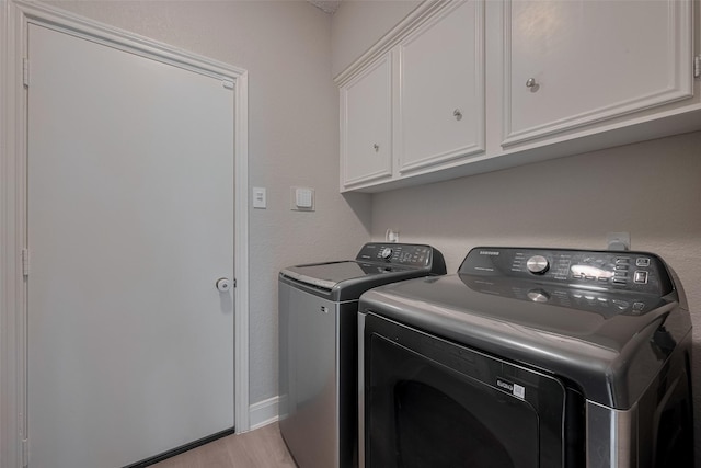 1709 Coles Farm Dr, Sugar Land, TX 77478 - laundry area featuring washing machine and clothes dryer, cabinet space, light wood-type flooring, and baseboards