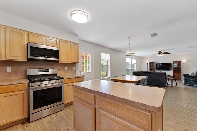 kitchen featuring stainless steel appliances, light brown cabinetry, light wood-style floors, ceiling fan, and light countertops