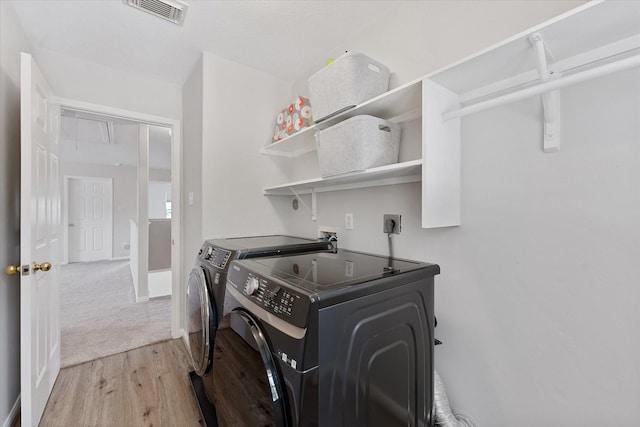 washroom featuring washer and dryer and wood finished floors