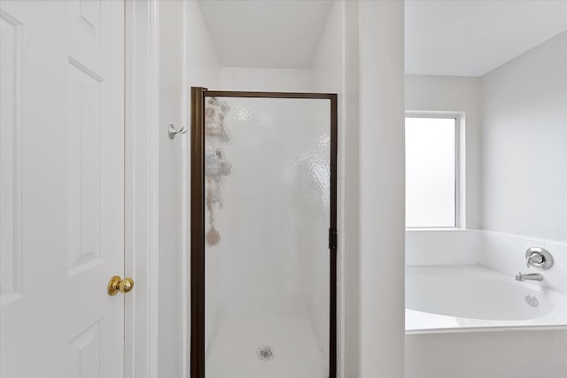 full bathroom featuring a stall shower and a bath
