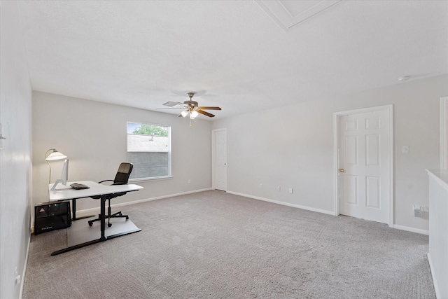 unfurnished office with carpet, ceiling fan, and baseboards
