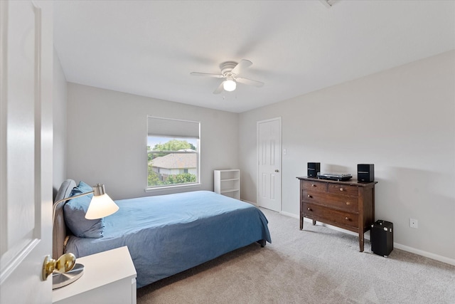 bedroom with light colored carpet, baseboards, and a ceiling fan