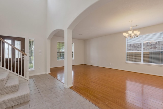 2712 Park Falls Dr, Pearland, TX 77584 - entryway with arched walkways, a chandelier, stairway, light wood-type flooring, and baseboards