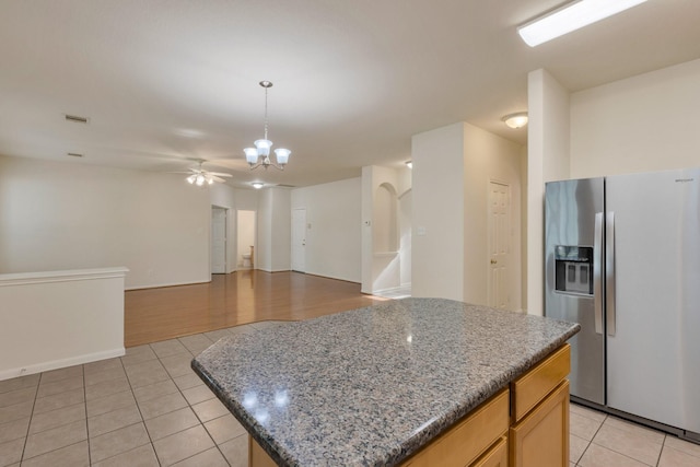 2712 Park Falls Dr, Pearland, TX 77584 - kitchen with stainless steel refrigerator with ice dispenser, light tile patterned flooring, a chandelier, a ceiling fan, and a kitchen island