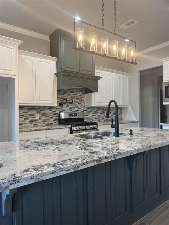 7510 Tram Rd, Beaumont, TX 77713 - kitchen with backsplash, stainless steel appliances, light stone counters, and ornamental molding