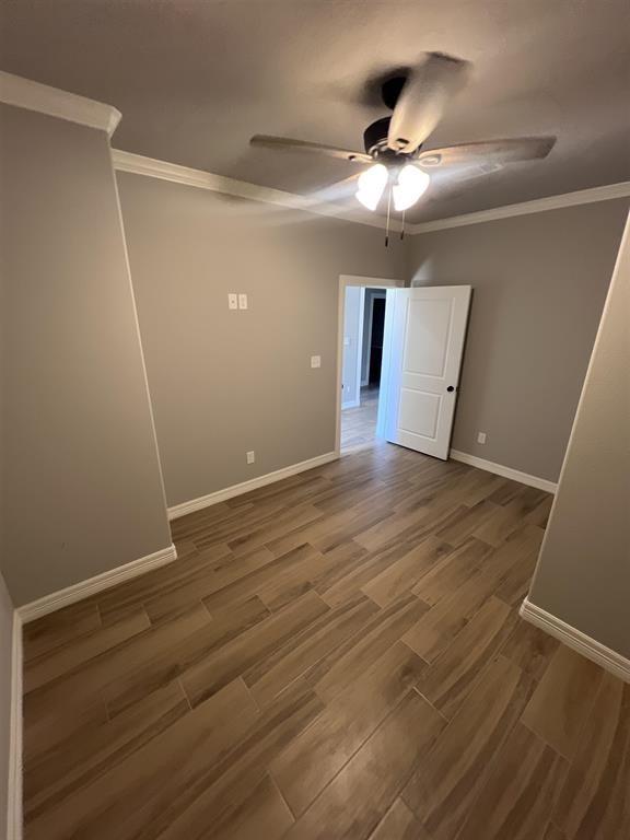 7510 Tram Rd, Beaumont, TX 77713 - unfurnished room featuring crown molding, a ceiling fan, baseboards, and wood finished floors