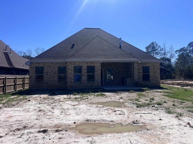 7510 Tram Rd, Beaumont, TX 77713 - back of house featuring brick siding, fence, and roof with shingles