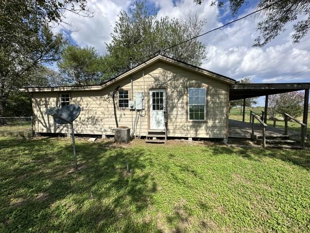 back of house featuring a yard, fence, entry steps, and cooling unit
