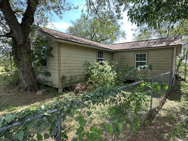 rear view of property with a shingled roof