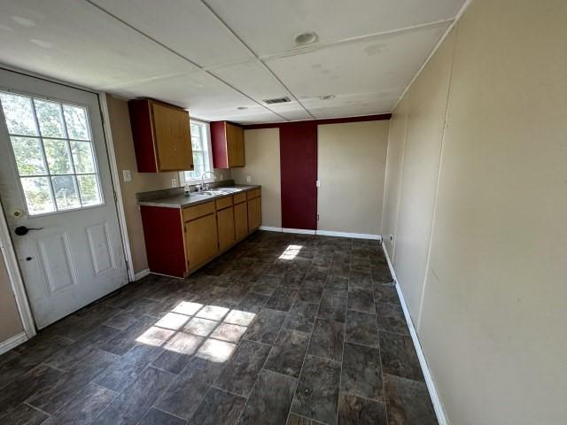 kitchen featuring a sink, light countertops, and baseboards