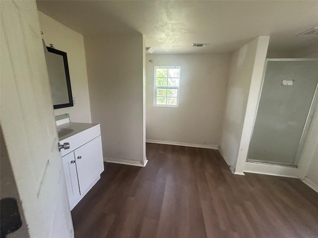 unfurnished dining area featuring baseboards, visible vents, and dark wood-style floors