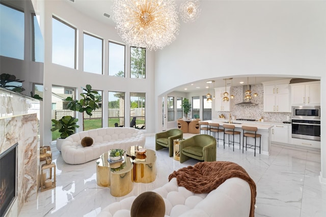 18114 Harbor Trail Ln, Conroe, TX 77302 - living area with arched walkways, a high ceiling, a chandelier, and marble finish floor