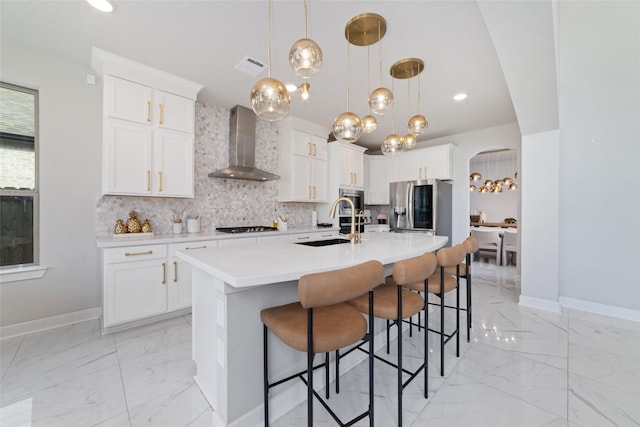 18114 Harbor Trail Ln, Conroe, TX 77302 - kitchen featuring marble finish floor, baseboards, wall chimney exhaust hood, a sink, and stainless steel appliances