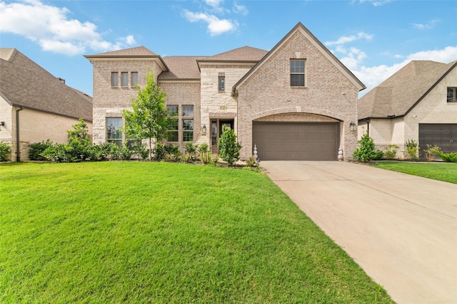 18114 Harbor Trail Ln, Conroe, TX 77302 - french provincial home featuring a garage, a front yard, driveway, and brick siding