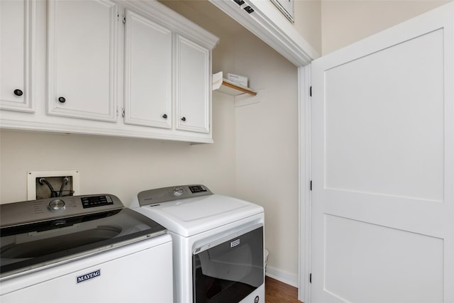 laundry room with cabinet space, dark wood finished floors, and washing machine and clothes dryer