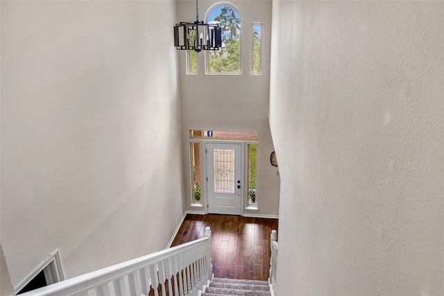 entrance foyer featuring a towering ceiling, a chandelier, and hardwood / wood-style floors