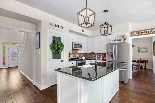 kitchen with decorative backsplash, white cabinets, stainless steel appliances, and dark wood-type flooring