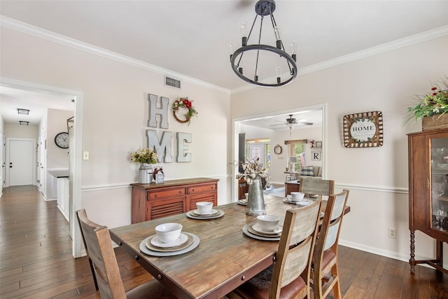 dining area with visible vents, crown molding, dark wood finished floors, baseboards, and a chandelier
