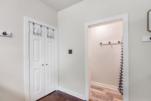 corridor with baseboards and dark wood-style floors