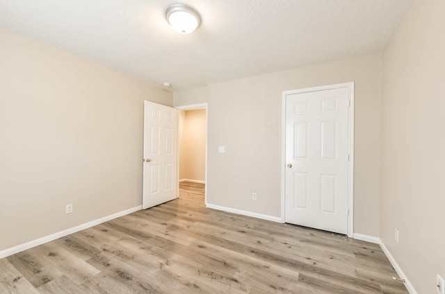 unfurnished bedroom with light wood-style floors and baseboards