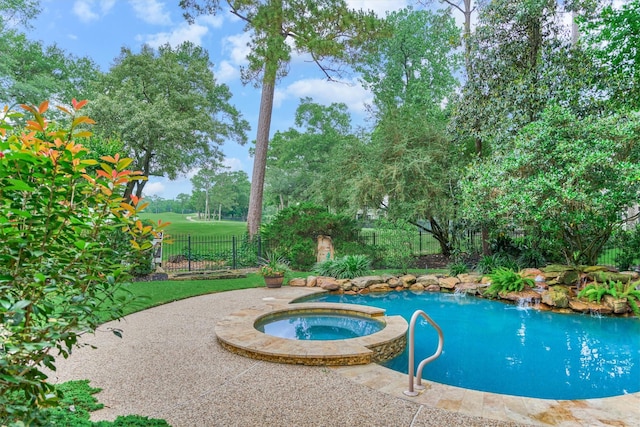view of swimming pool featuring fence and a pool with connected hot tub