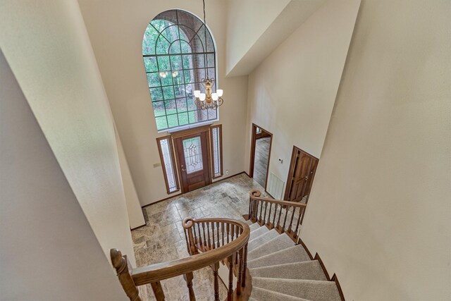 entryway with a high ceiling, a chandelier, and stairway