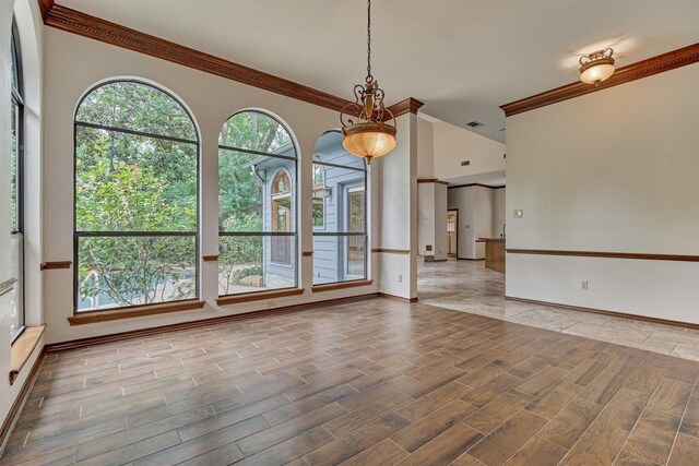 spare room with ornamental molding, baseboards, and wood finished floors