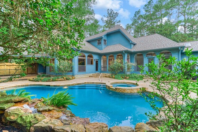 view of swimming pool featuring an in-ground hot tub, fence, and a patio area