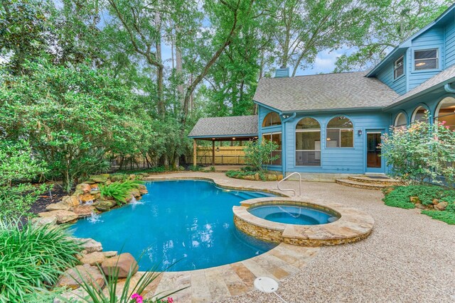view of pool featuring a fenced backyard, a pool with connected hot tub, and a patio area