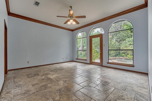 unfurnished room with stone tile floors, baseboards, ceiling fan, and ornamental molding