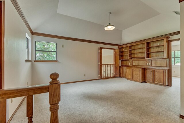 unfurnished living room with light carpet, lofted ceiling, ornamental molding, baseboards, and a raised ceiling