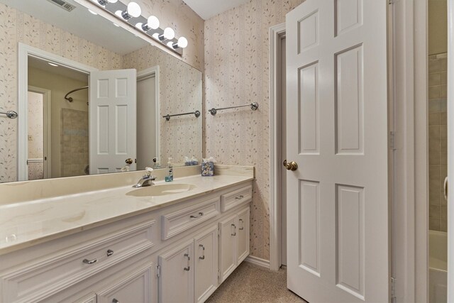 full bathroom featuring wallpapered walls, a shower, and vanity