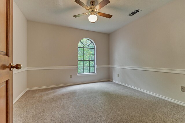 spare room with carpet, a ceiling fan, and baseboards