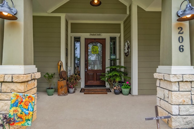 entrance to property featuring covered porch and stone siding