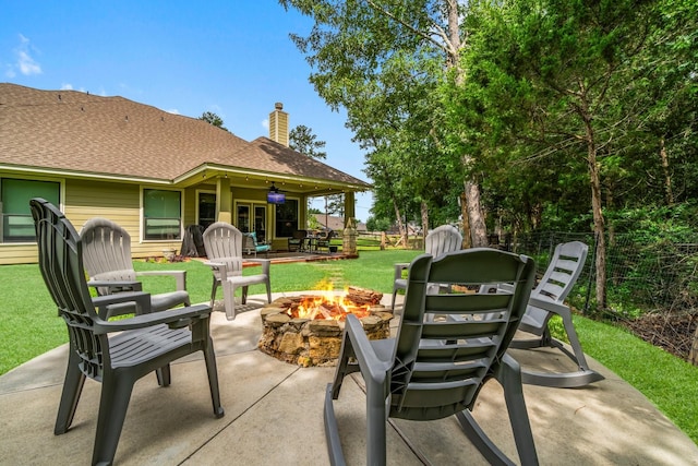 view of patio / terrace featuring fence, a fire pit, and french doors