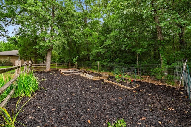 view of yard featuring fence and a vegetable garden