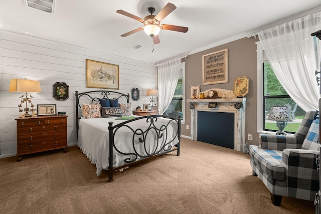carpeted bedroom featuring multiple windows, ornamental molding, and visible vents
