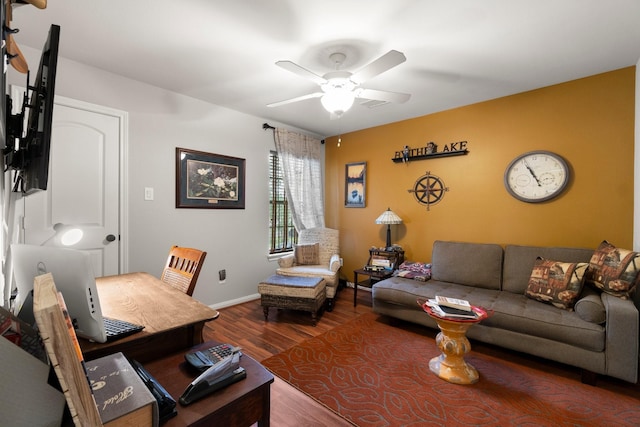 living area featuring baseboards, a ceiling fan, and wood finished floors