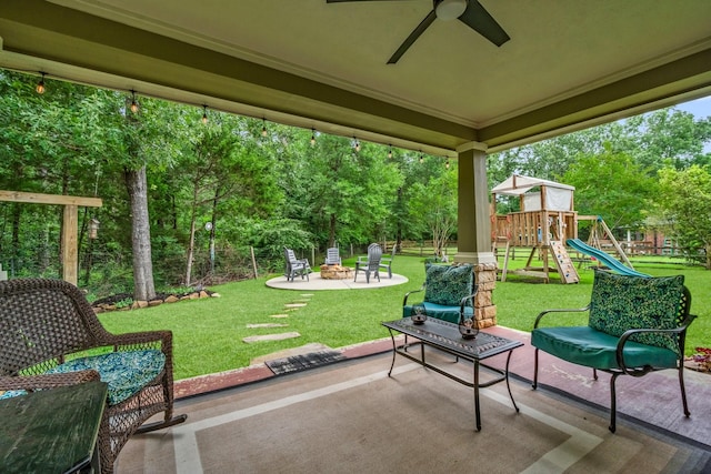 view of patio with a playground, ceiling fan, and an outdoor fire pit