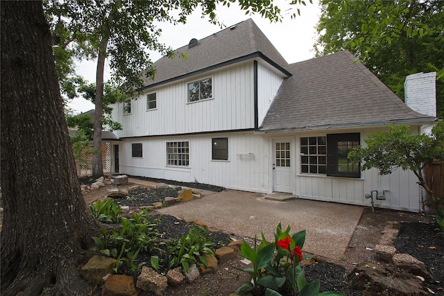 1719 Wagon Gap Trl, Houston, TX 77090 - back of property with a shingled roof, a patio area, and a chimney