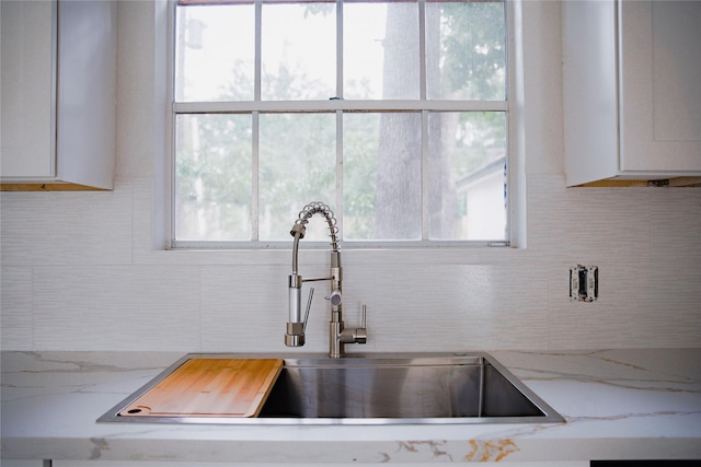 1719 Wagon Gap Trl, Houston, TX 77090 - kitchen featuring backsplash, white cabinets, a sink, and plenty of natural light