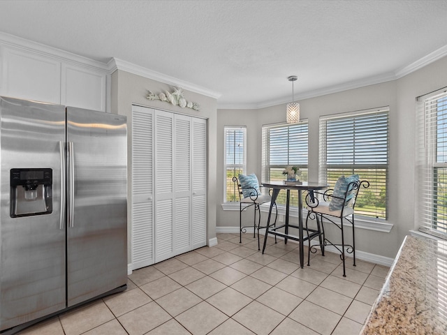 4035 Estuary Ct, Galveston, TX 77554 - kitchen featuring stainless steel fridge, baseboards, healthy amount of natural light, ornamental molding, and a textured ceiling