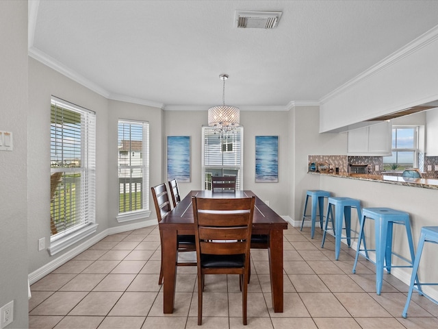 4035 Estuary Ct, Galveston, TX 77554 - dining area featuring a chandelier, ornamental molding, light tile patterned flooring, and baseboards