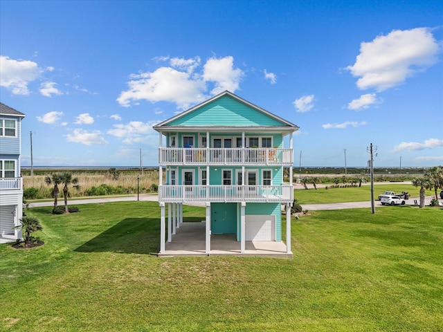 4035 Estuary Ct, Galveston, TX 77554 - back of property featuring an attached garage, a balcony, and a yard