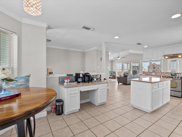 4035 Estuary Ct, Galveston, TX 77554 - kitchen with stainless steel electric range oven, a center island, white cabinetry, open floor plan, and light tile patterned floors