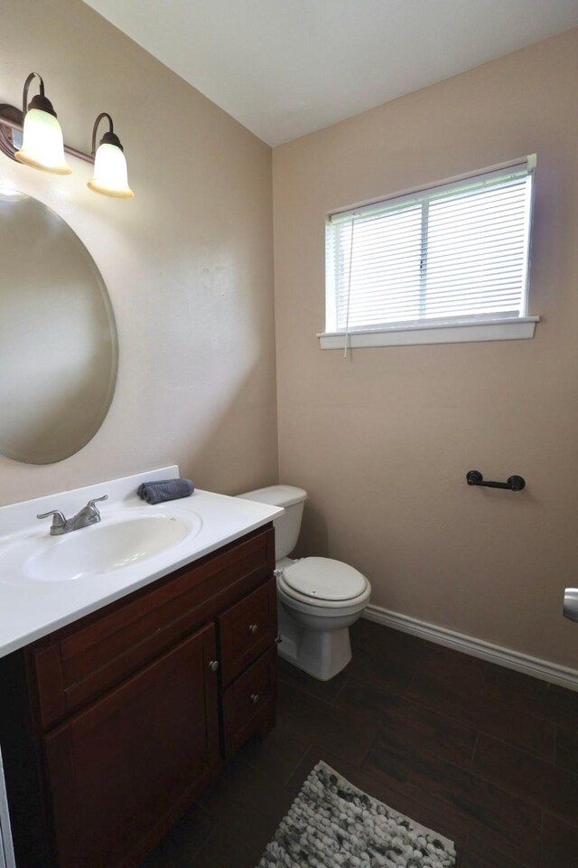 1217 E Brown Ln, Deer Park, TX 77536 - bathroom featuring toilet, vanity, and baseboards