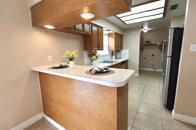 1217 E Brown Ln, Deer Park, TX 77536 - kitchen with appliances with stainless steel finishes, a peninsula, light countertops, light tile patterned floors, and baseboards