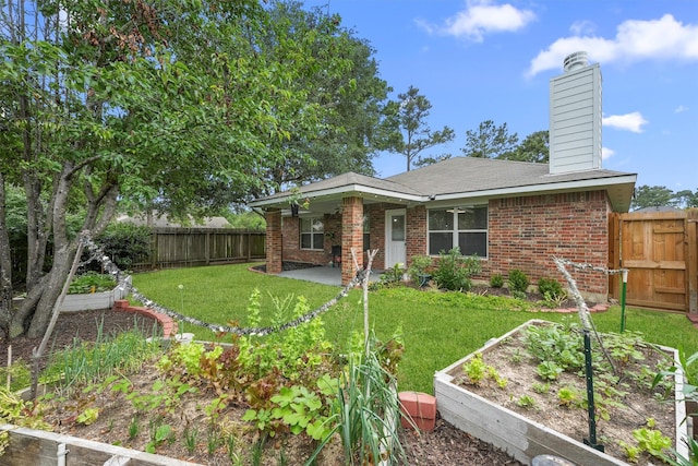 13935 Pueblo Run, Cypress, TX 77429 - back of property with a chimney, a yard, a vegetable garden, and brick siding
