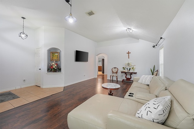 13935 Pueblo Run, Cypress, TX 77429 - living area with visible vents, wood finished floors, baseboards, arched walkways, and vaulted ceiling