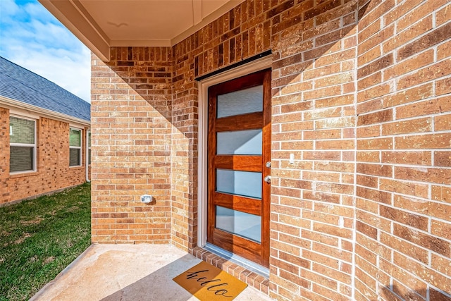 entrance to property featuring brick siding
